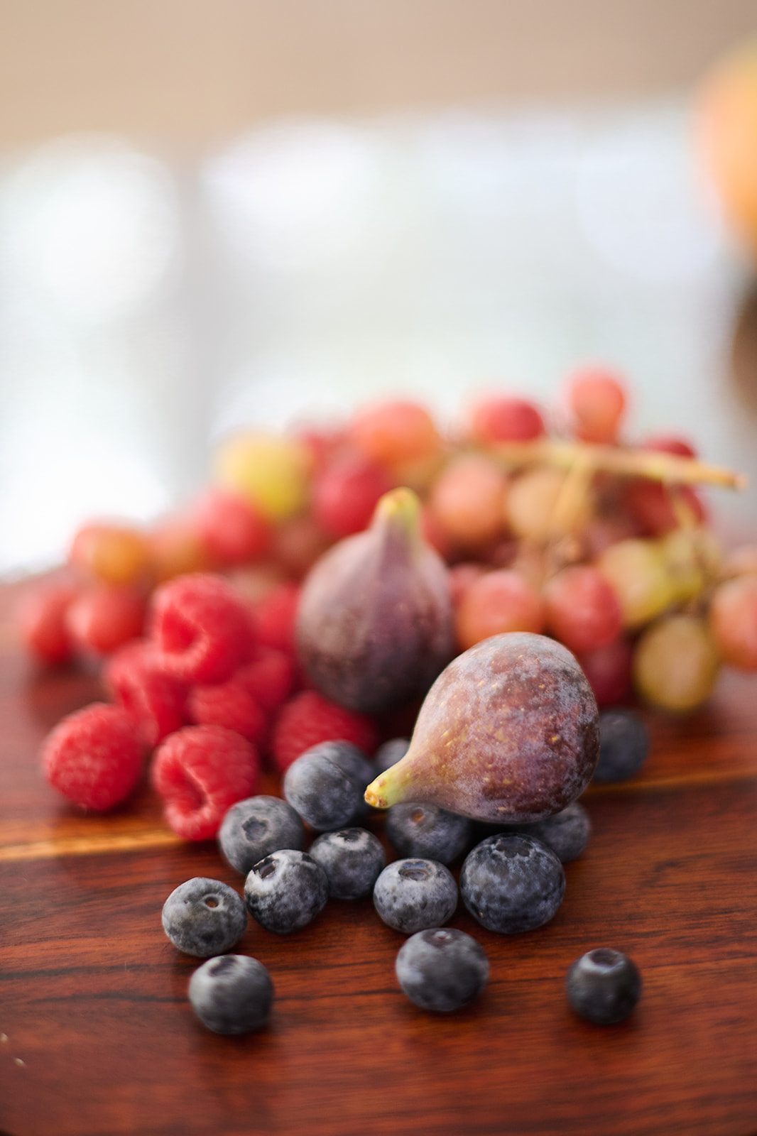 Berries, figs and grapes on a wooden board