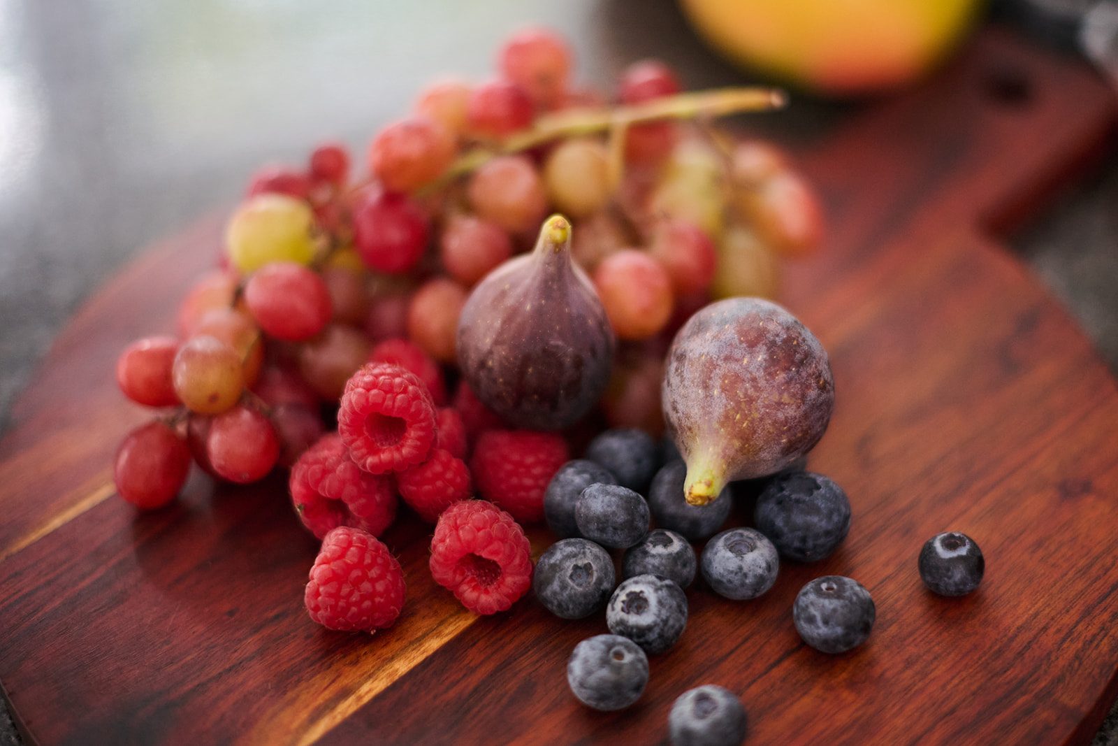 Berries and figs on a wooden board